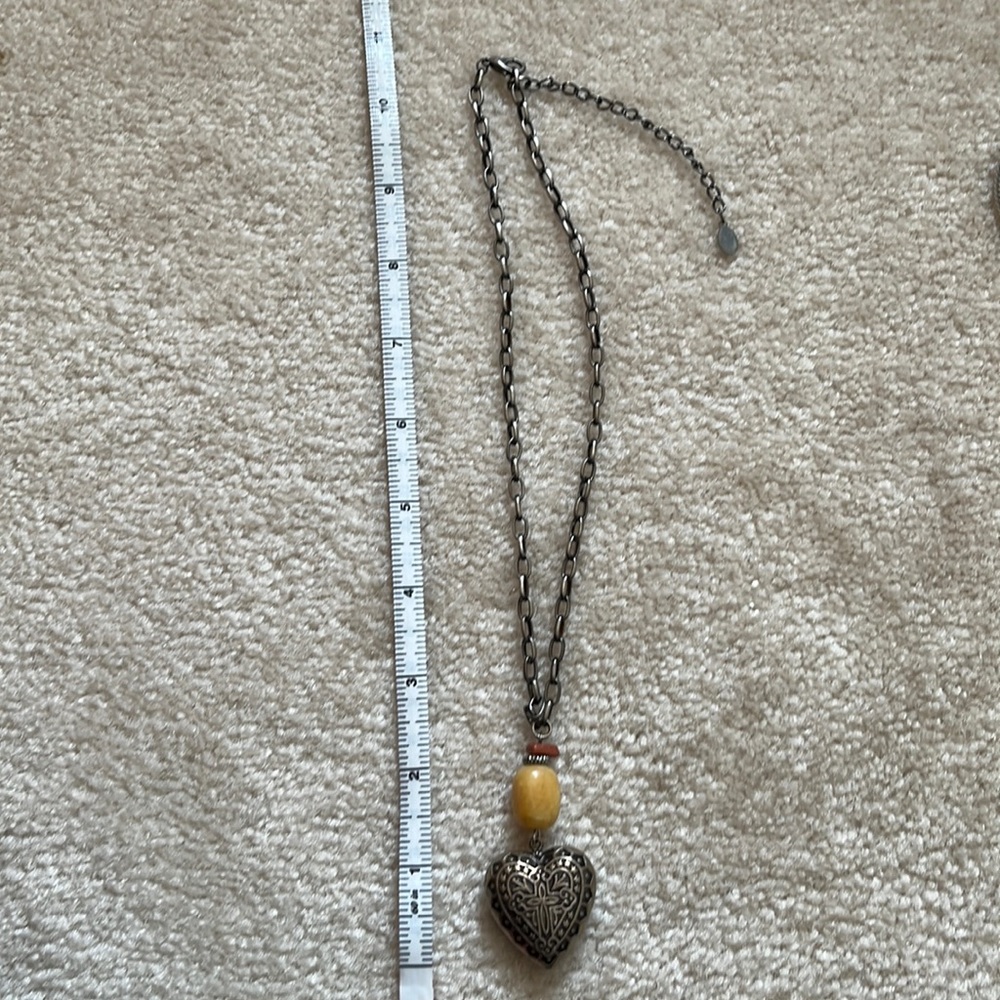 Pewter toned heart necklace. Appears to be a cross on heart